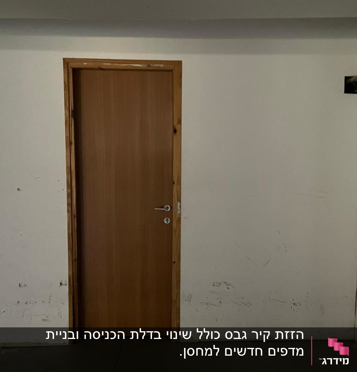 דלת עץ מותקנת בקיר לבן עם צינור חשוף